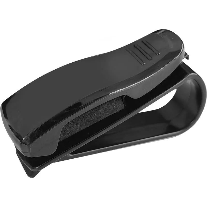 Black plastic car sun visor clip holding a pair of sunglasses and a parking ticket.