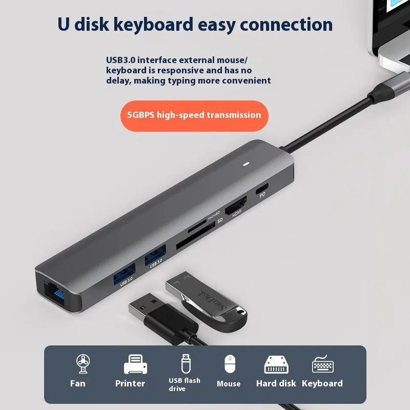 Silver USB C 7-in-1 hub dongle with SD card slot, micro SD slot, and USB C PD charging port.