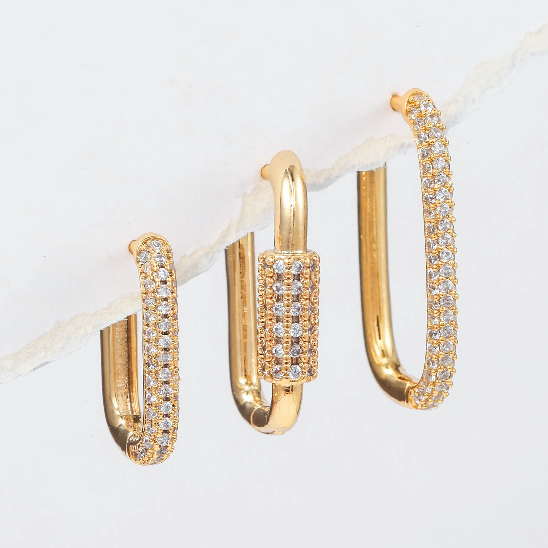 Three geometric square ear clips with inlaid zircon stones in gold and white gold colours