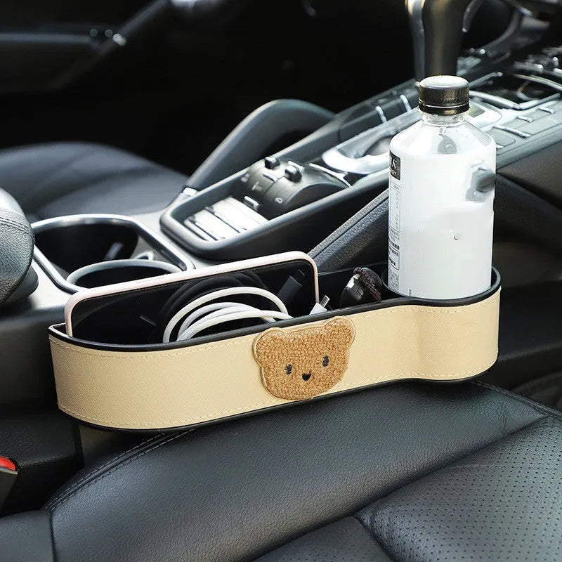 Leather car seat gap storage box with a cartoon bear design hanging next to a car seat.