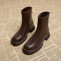 Women's black ankle boots with a flat thick heel, round toe, and a back zip fastener.