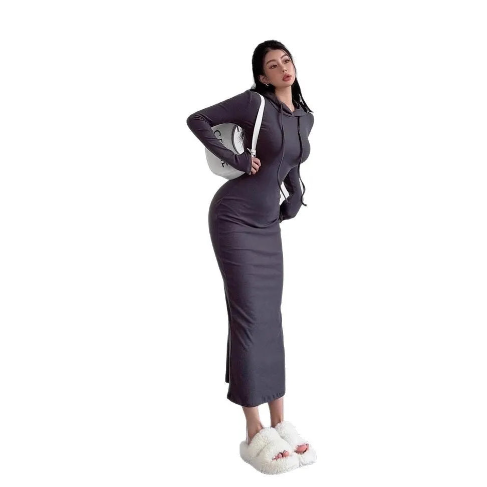 A woman wearing a light grey hooded long sleeve sheath dress with a high waist.