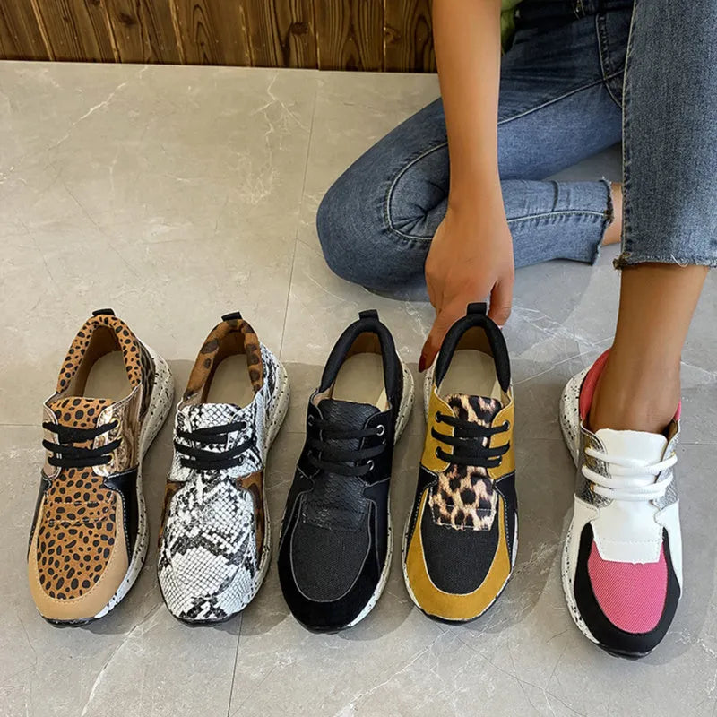Women's casual flat sneakers in leopard print with suede upper and a low wedge heel.