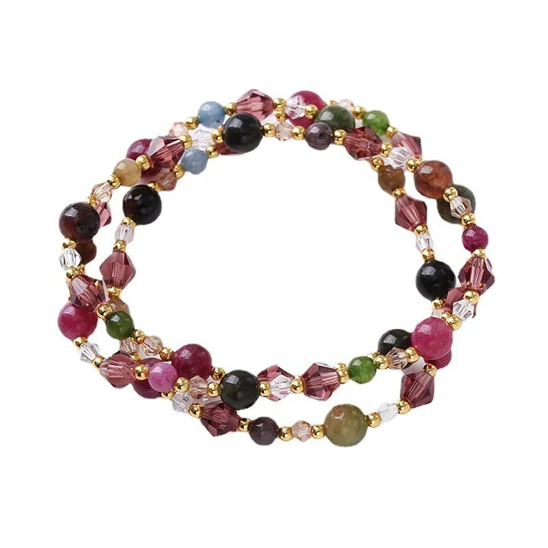 Handmade adjustable bracelet with three crystal rings: tourmaline, strawberry quartz, and amethyst.