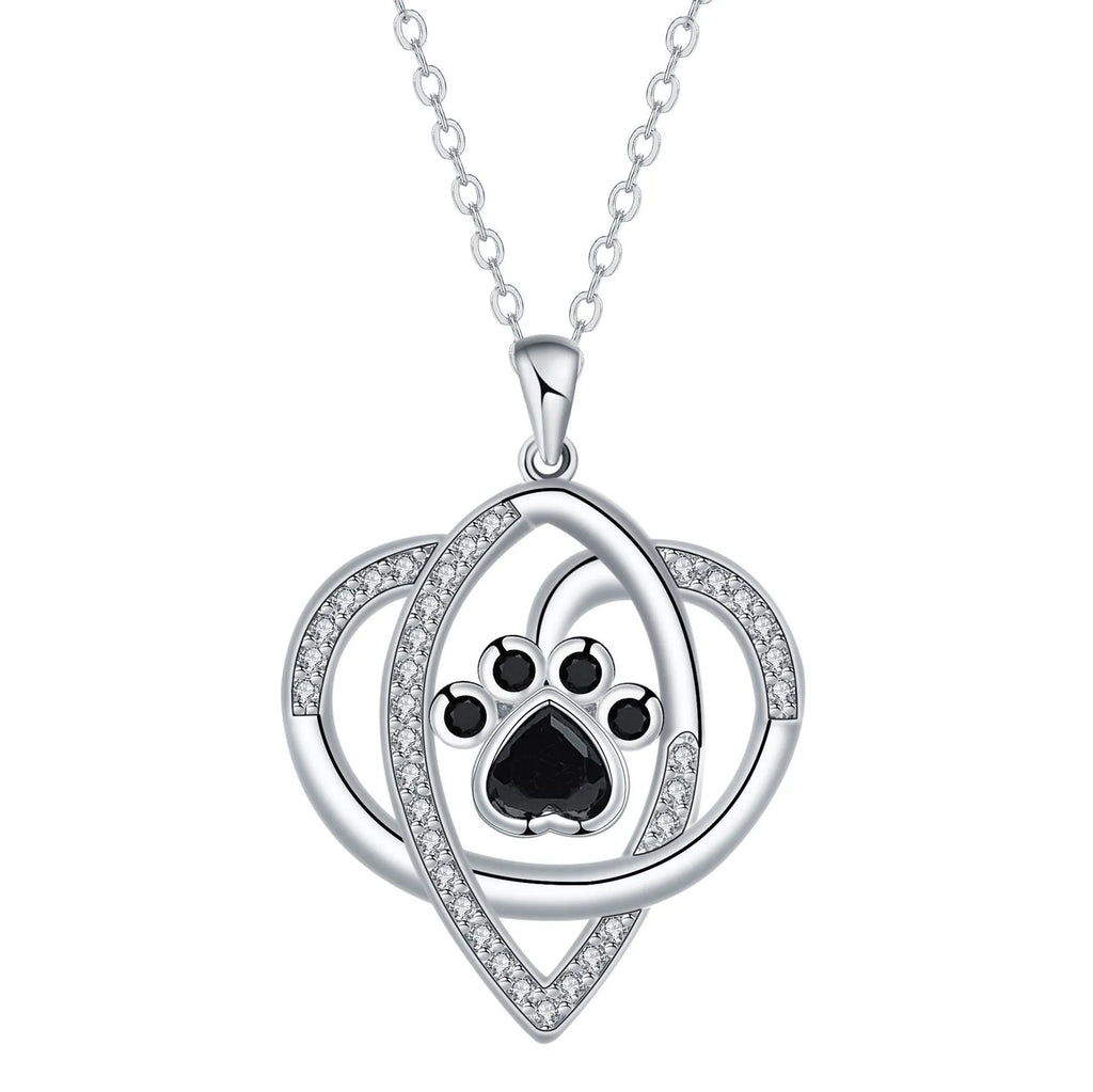 Close-up of a copper pendant necklace showing a charm with dog paw and cat footprint designs on a cross chain.