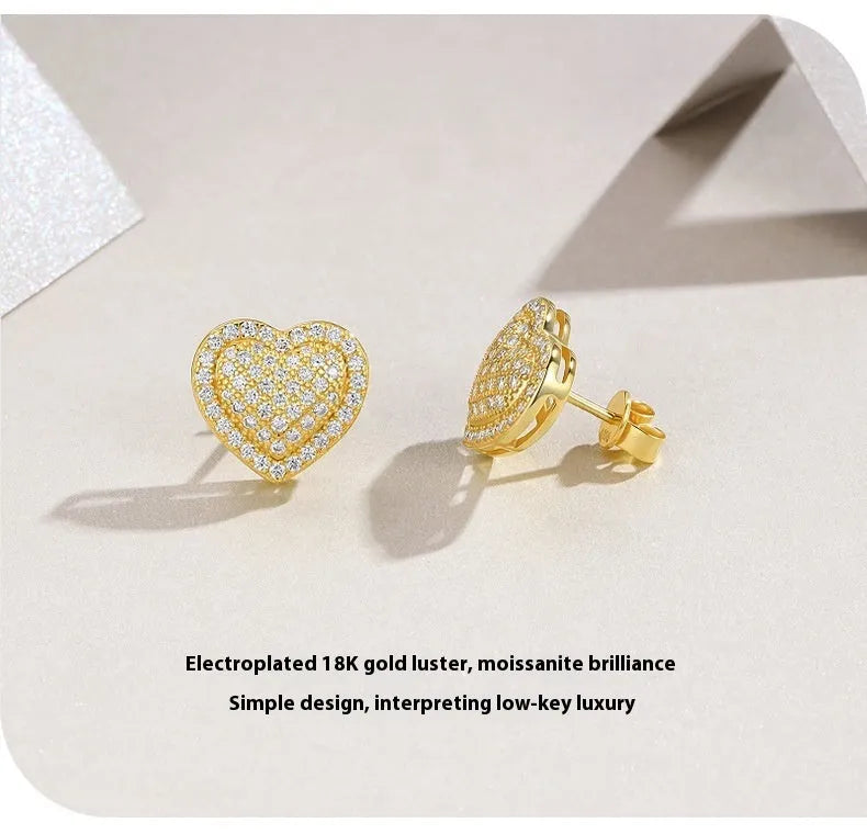 A pair of gold-coloured heart-shaped moissanite stud earrings on S925 silver posts.
