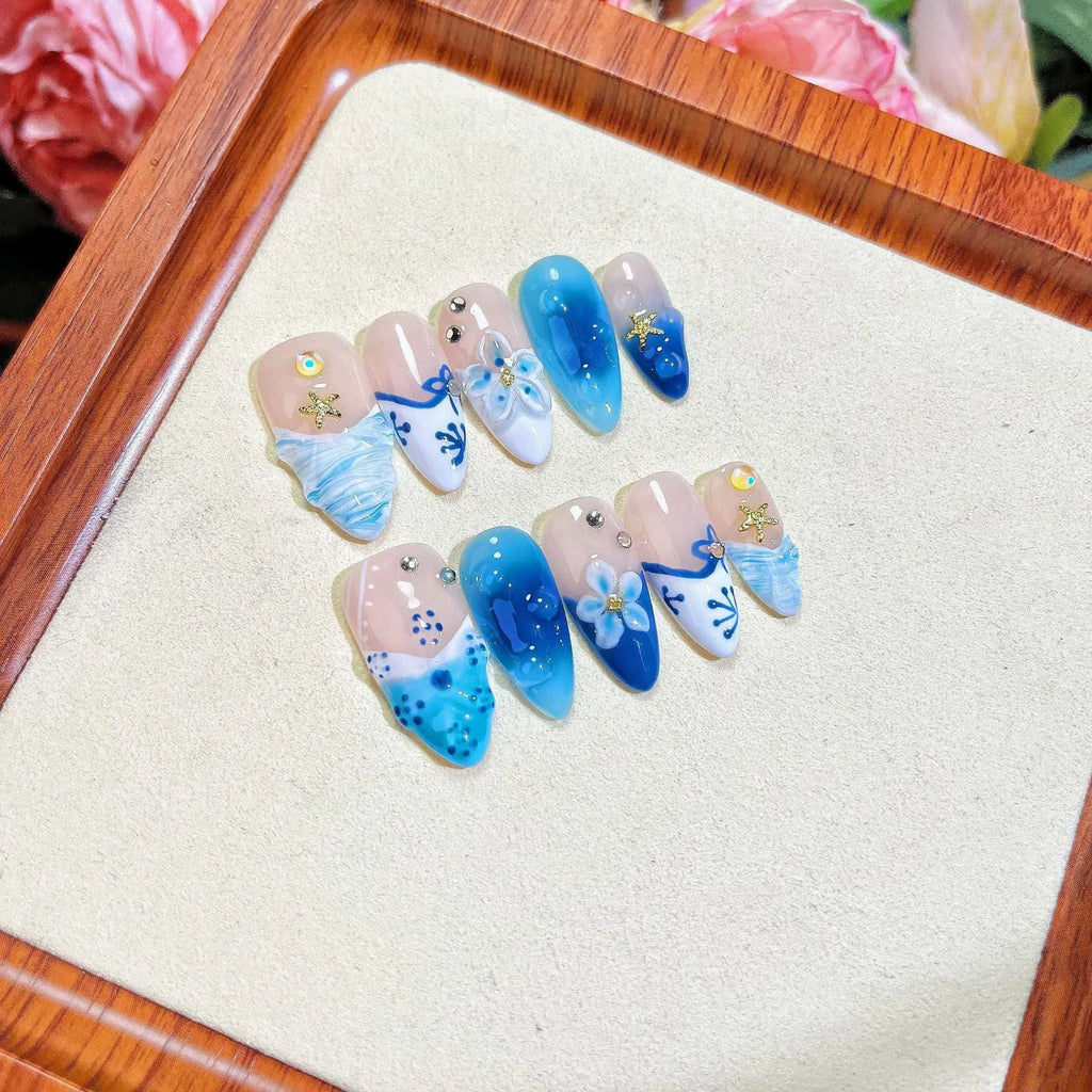 Blue hand-painted carved plastic fake nails set in sizes XS, S, M, L.