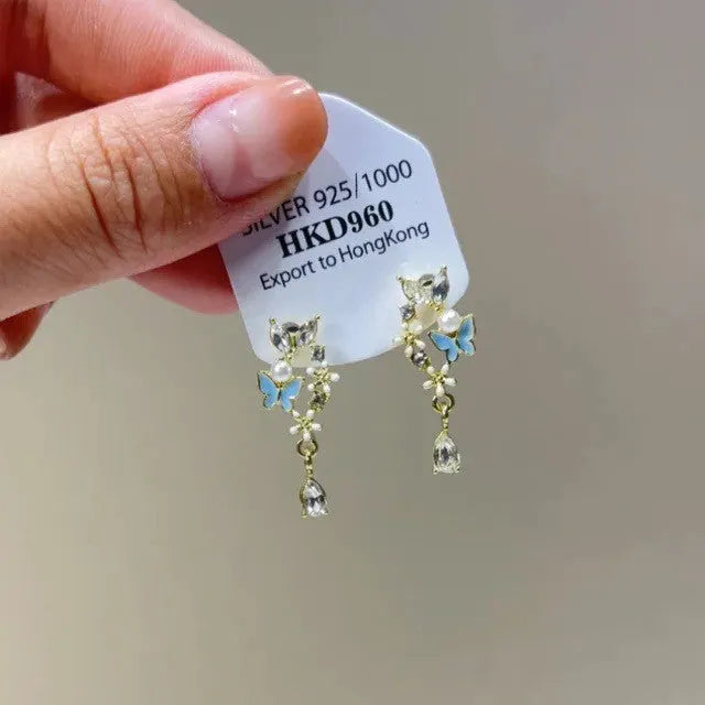 Geometric heart-shaped women's clip-on earrings with rhinestone stars and a tassel detail in a metallic finish.