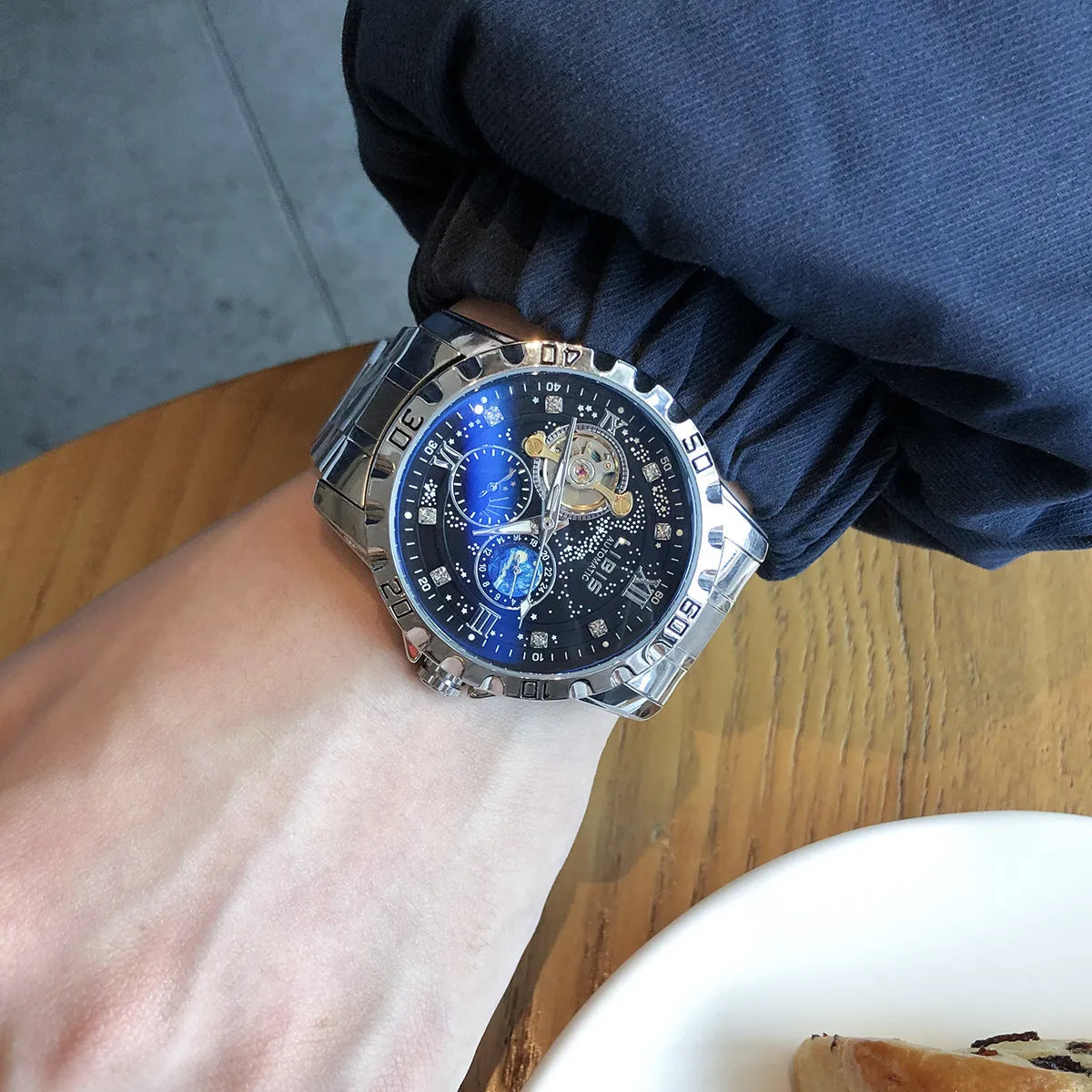 Men's silver case automatic mechanical watch with black starry luminous dial and leather strap.