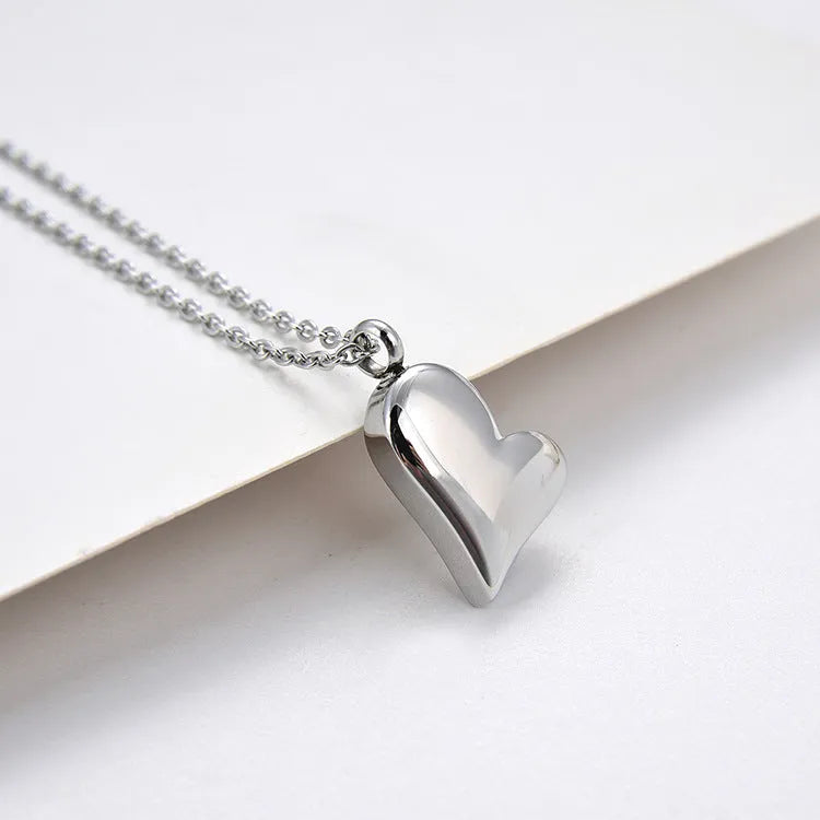 Silver curved peach heart pendant on stainless steel necklace with adjustable chain
