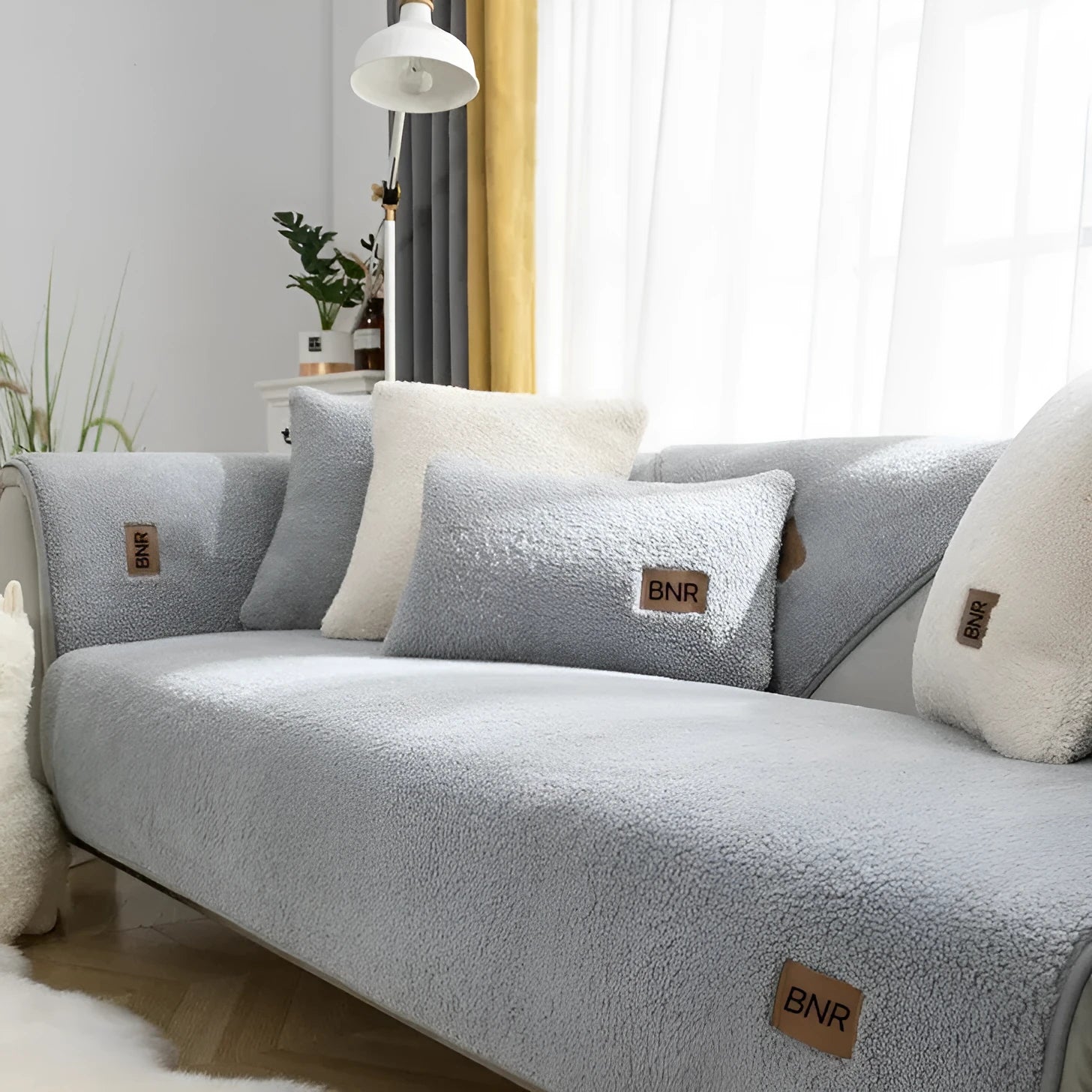 Solid colour lambswool sofa cover on a couch, showing cloth liner and neat fit.