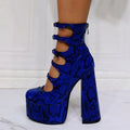 Women's black platform high heels with a thick heel, patent leather upper, and a serpentine design buckle.