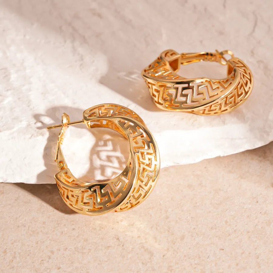 A pair of silver geometric women's stud earrings with a twisted round hollow design.