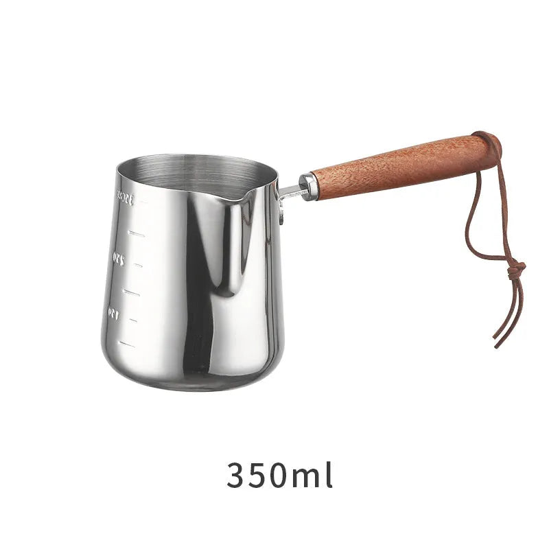 Stainless steel coffee cup with wooden handle showing interior measurement scale for latte art