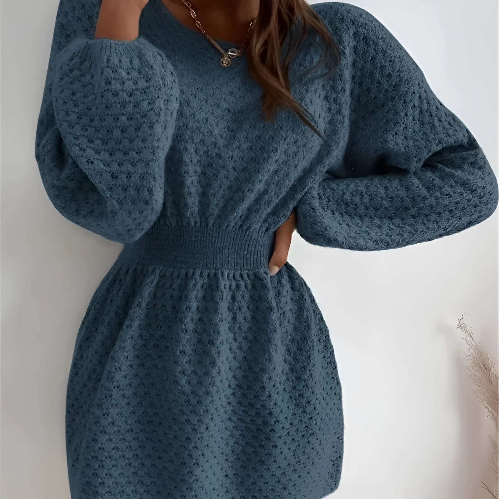 Blue women's knitted dress with crochet flower detail, round neck, and fitted waist