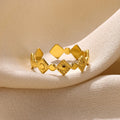 Geometric gold titanium steel ring on a neutral background.