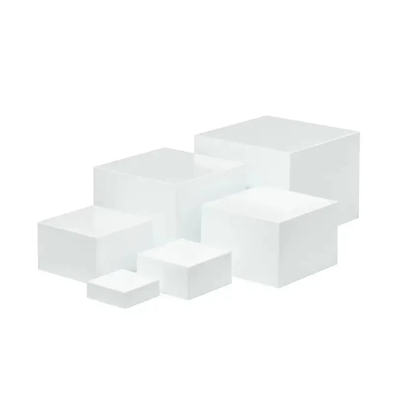 White plastic cube-shaped dessert display stands arranged on countertop for cake presentation