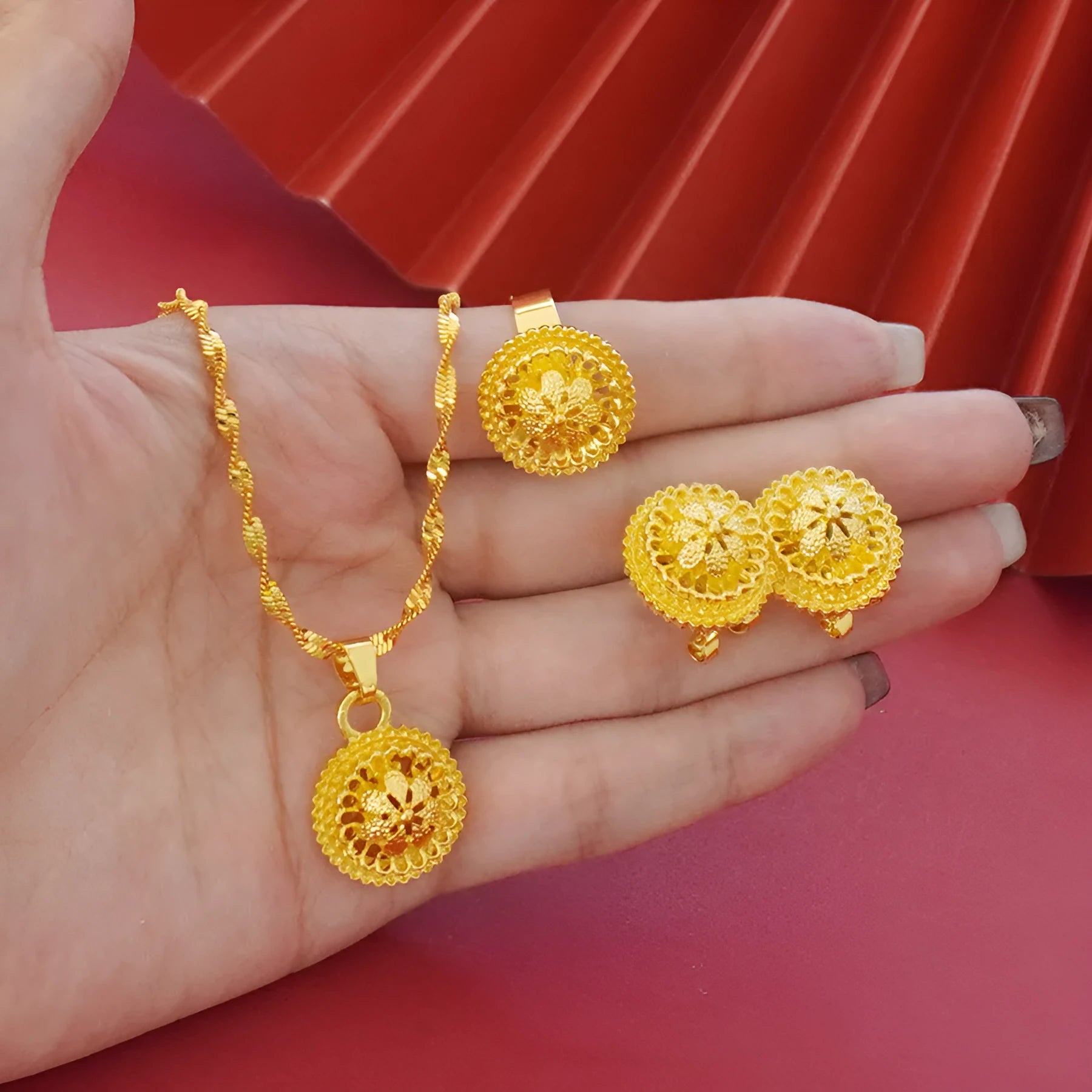Gold-plated three-piece jewellery set showing necklace with floral pendant, matching earrings, and ring on a water wave chain.