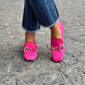 Green suede flat loafers with a round toe and metal fastener on the vamp.