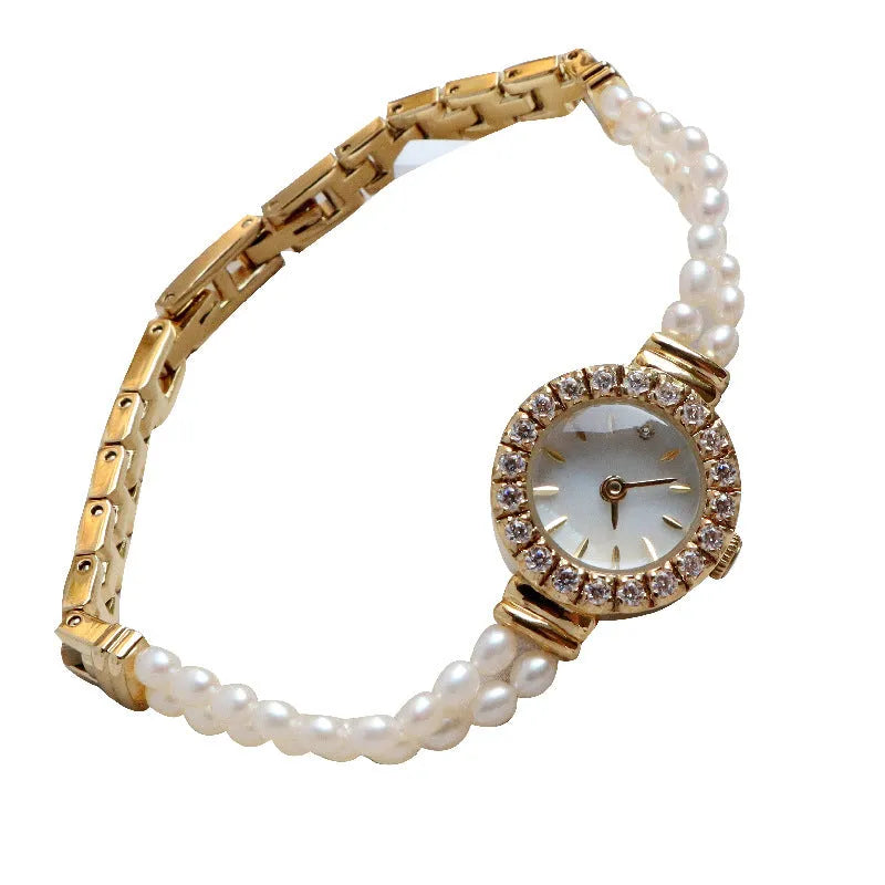 Women's light gold bracelet watch with freshwater pearls and an 18mm round dial.