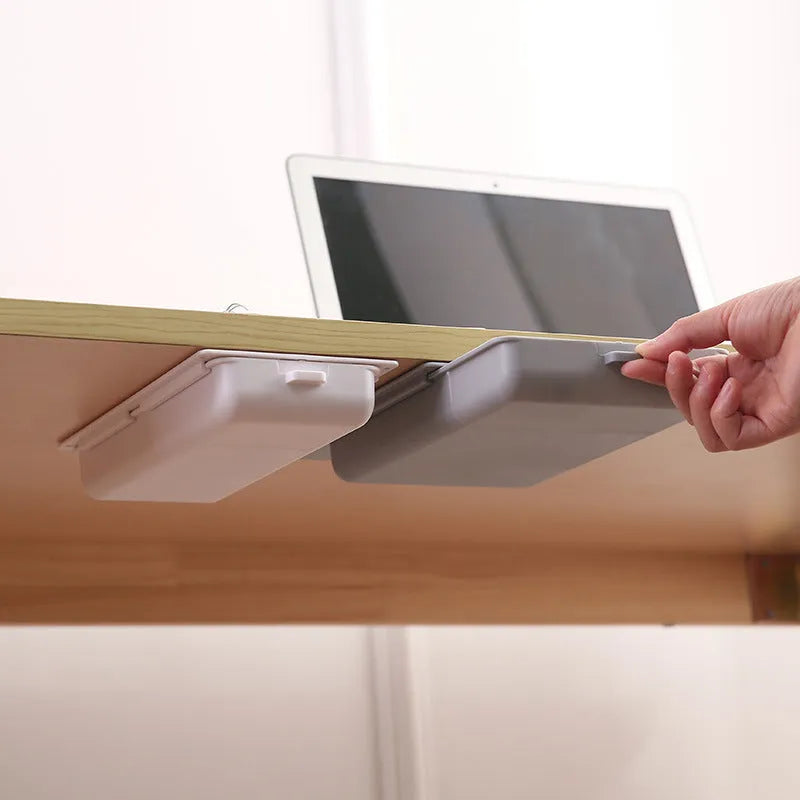White plastic storage drawer with a cover and internal grid compartment, designed for adhesive mounting under tables