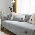 Solid colour lambswool sofa cover on a couch, showing cloth liner and neat fit.
