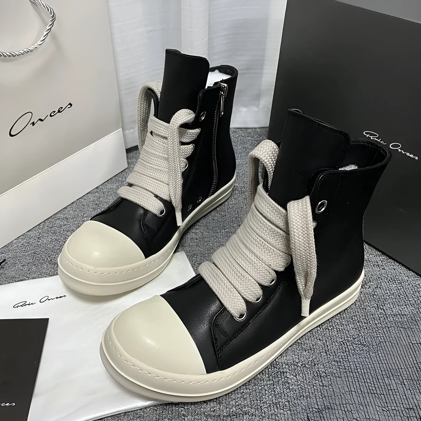 Genuine leather high-top sneakers in black with side zipper and rubber sole.