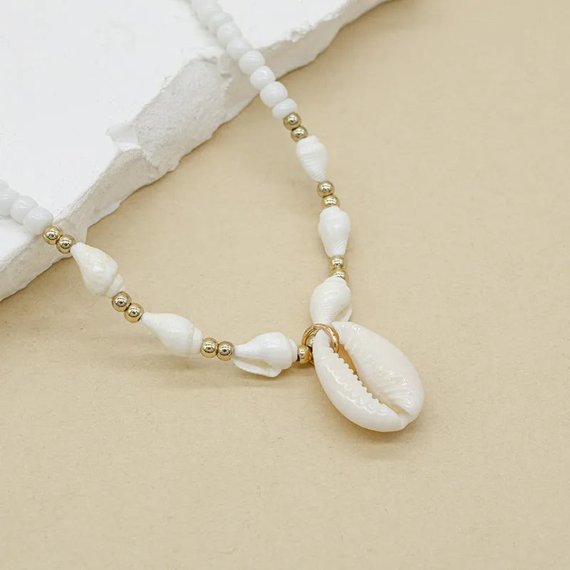 White conch shell mother-of-pearl pendant necklace on a silver electroplated chain for women.