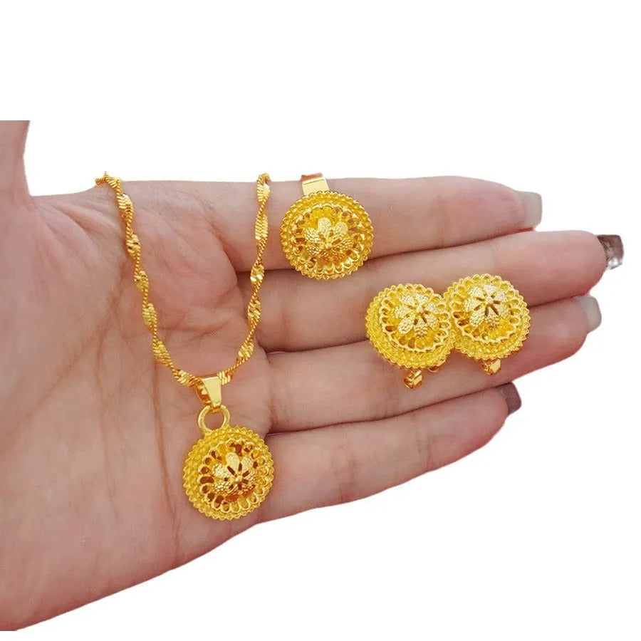 Gold-plated three-piece jewellery set showing necklace with floral pendant, matching earrings, and ring on a water wave chain.