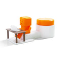Orange plastic Take a Shot vent decompression toy with a rotating table on a desk.