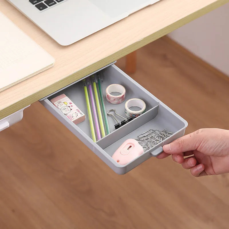 White plastic storage drawer with a cover and internal grid compartment, designed for adhesive mounting under tables