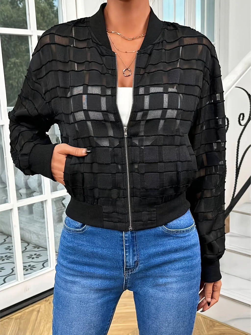 Black women's jacket with geometric pattern and semi-transparent polyester fabric showing zipper closure