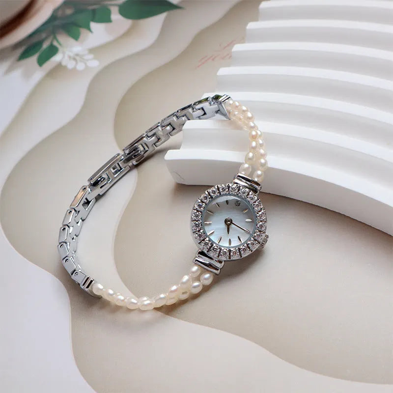 Women's light gold bracelet watch with freshwater pearls and an 18mm round dial.