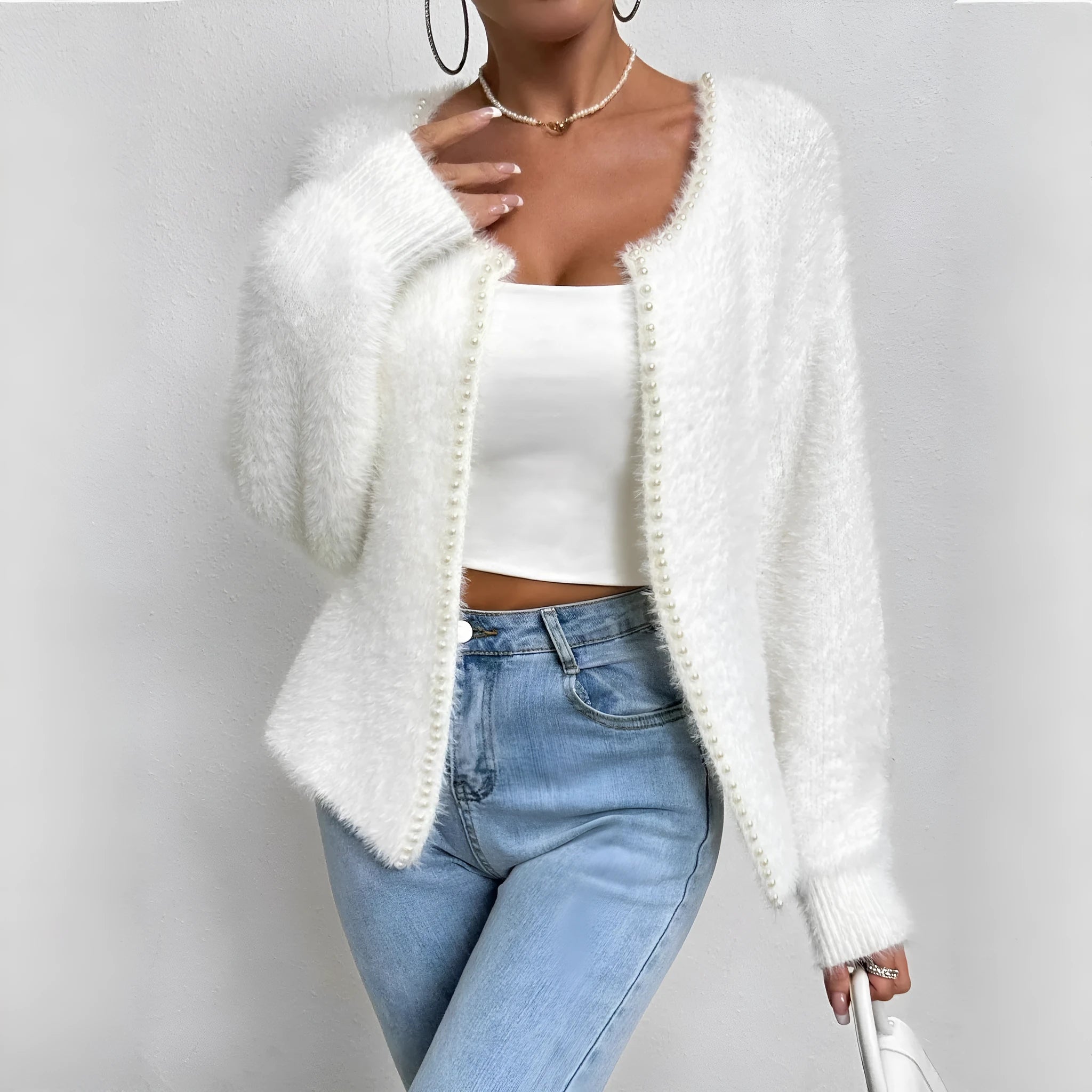 White women's V-neck cardigan with beaded knit detail on a hanger.