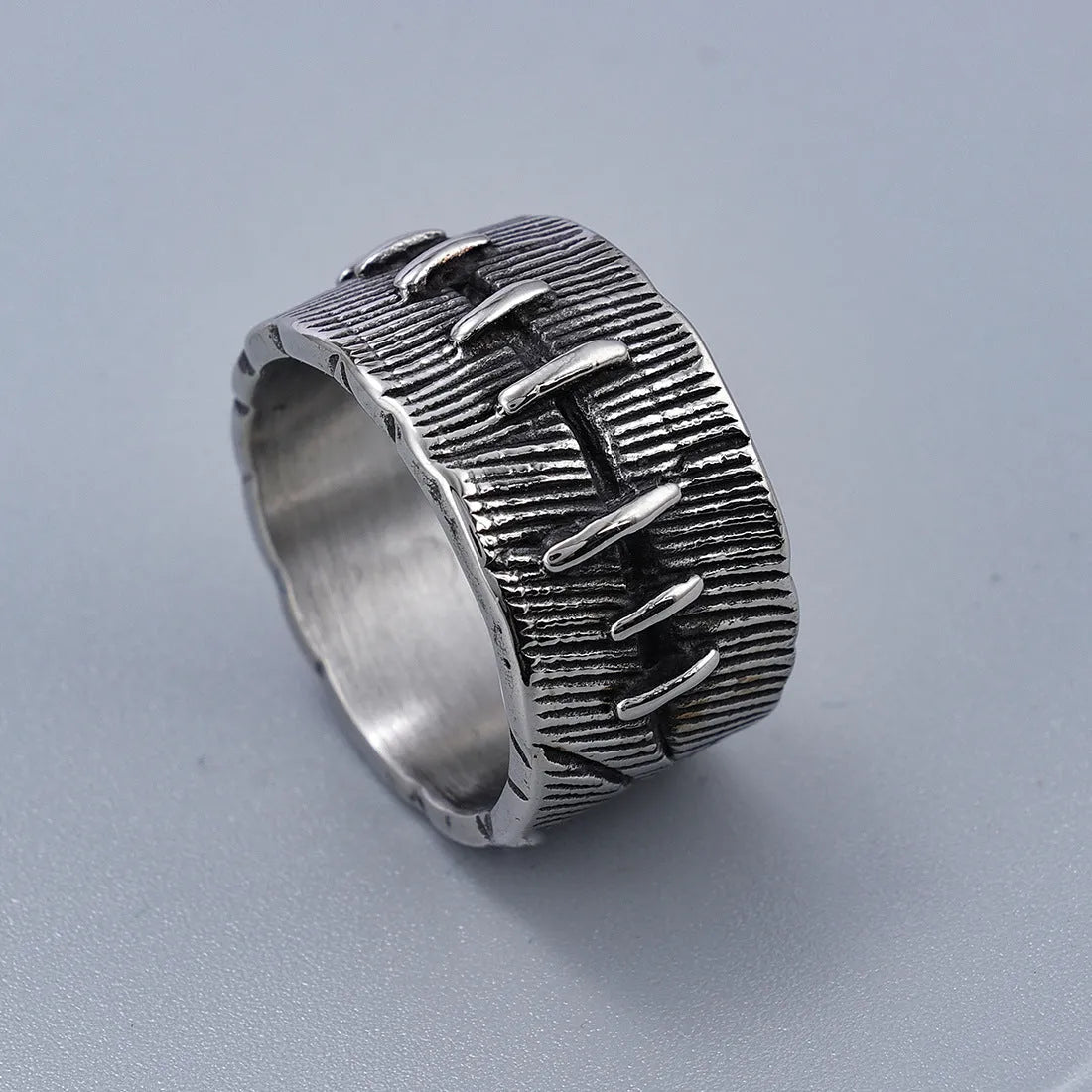Titanium steel geometric U-shaped double ring with stitched texture in a retro colour.