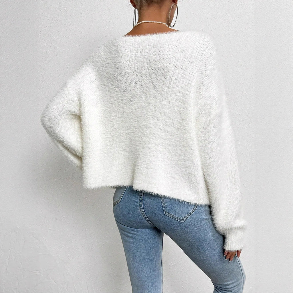 White women's V-neck cardigan with beaded knit detail on a hanger.