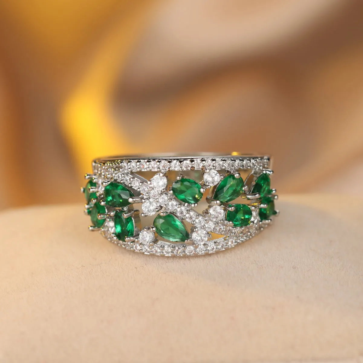 Women's hollow round fashion ring in gold tone with blue stones, showing openwork design.