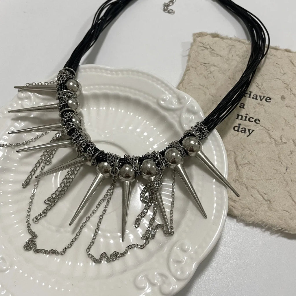 Women's leather tassel necklace with winding beads and silver rivet details in picture colour.