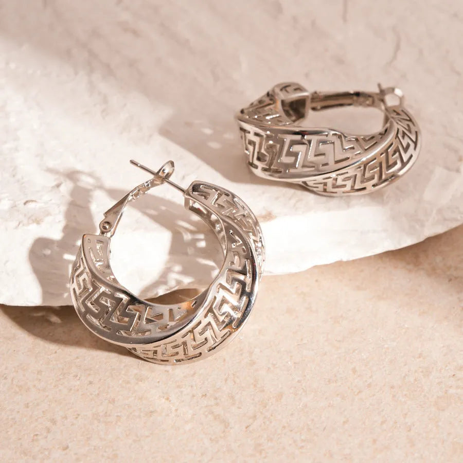 A pair of silver geometric women's stud earrings with a twisted round hollow design.