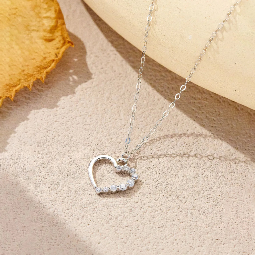 Sterling silver hollow heart pendant necklace on a regular chain, shown in a white gold colour finish.