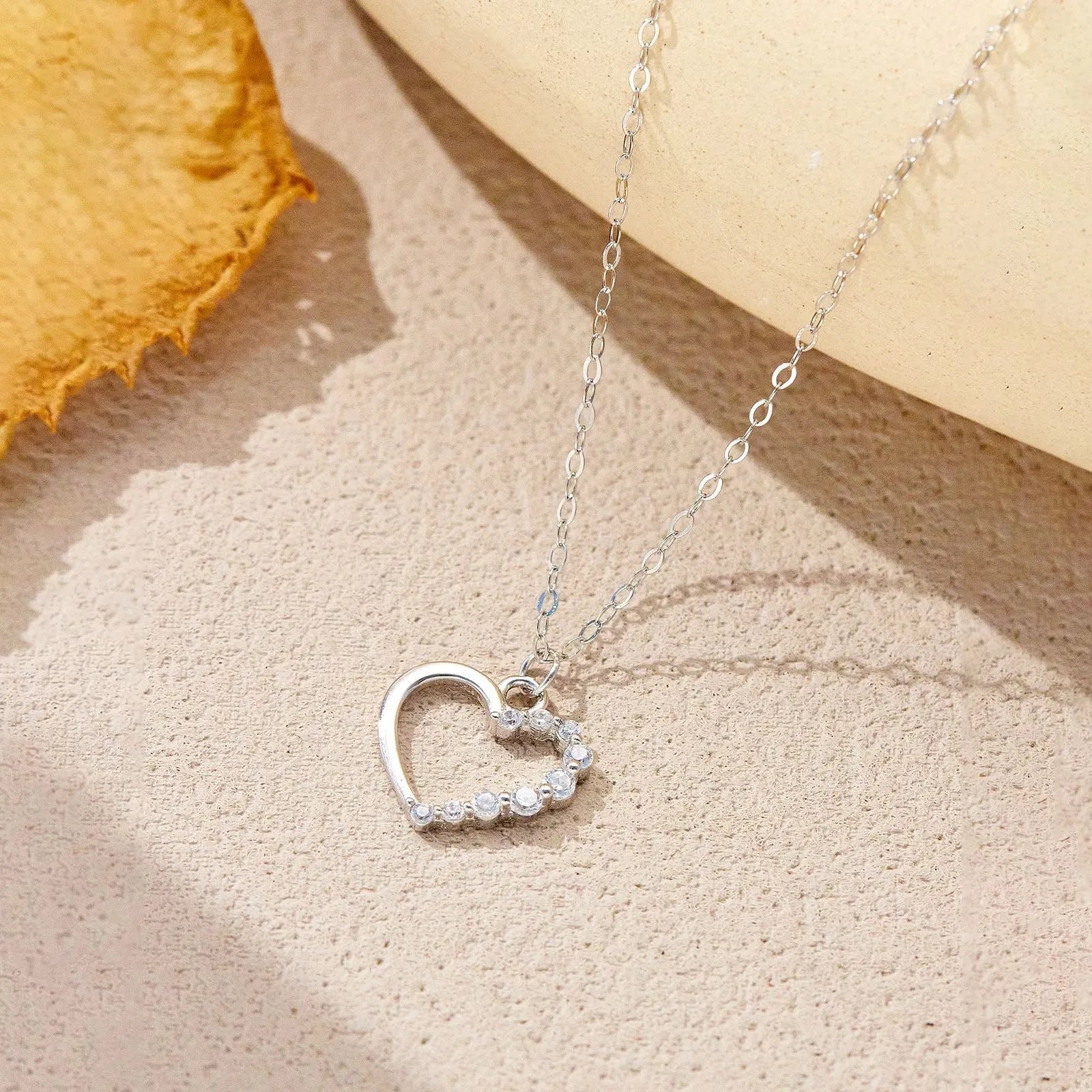 Sterling silver hollow heart pendant necklace on a regular chain, shown in a white gold colour finish.