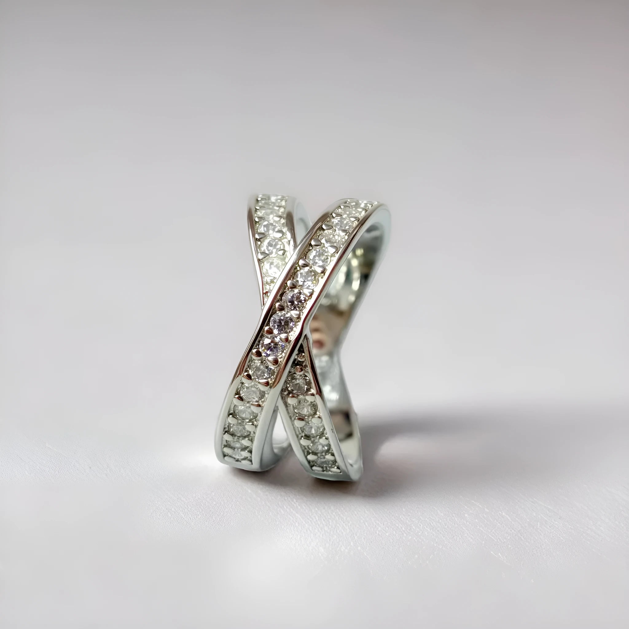 Silver cross ring with micro-inlaid zircon stones and geometric heart design on hand
