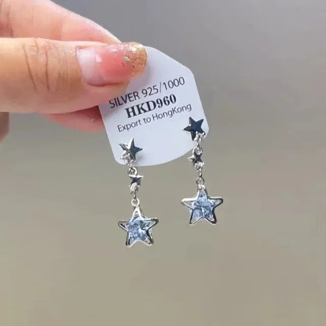Geometric heart-shaped women's clip-on earrings with rhinestone stars and a tassel detail in a metallic finish.