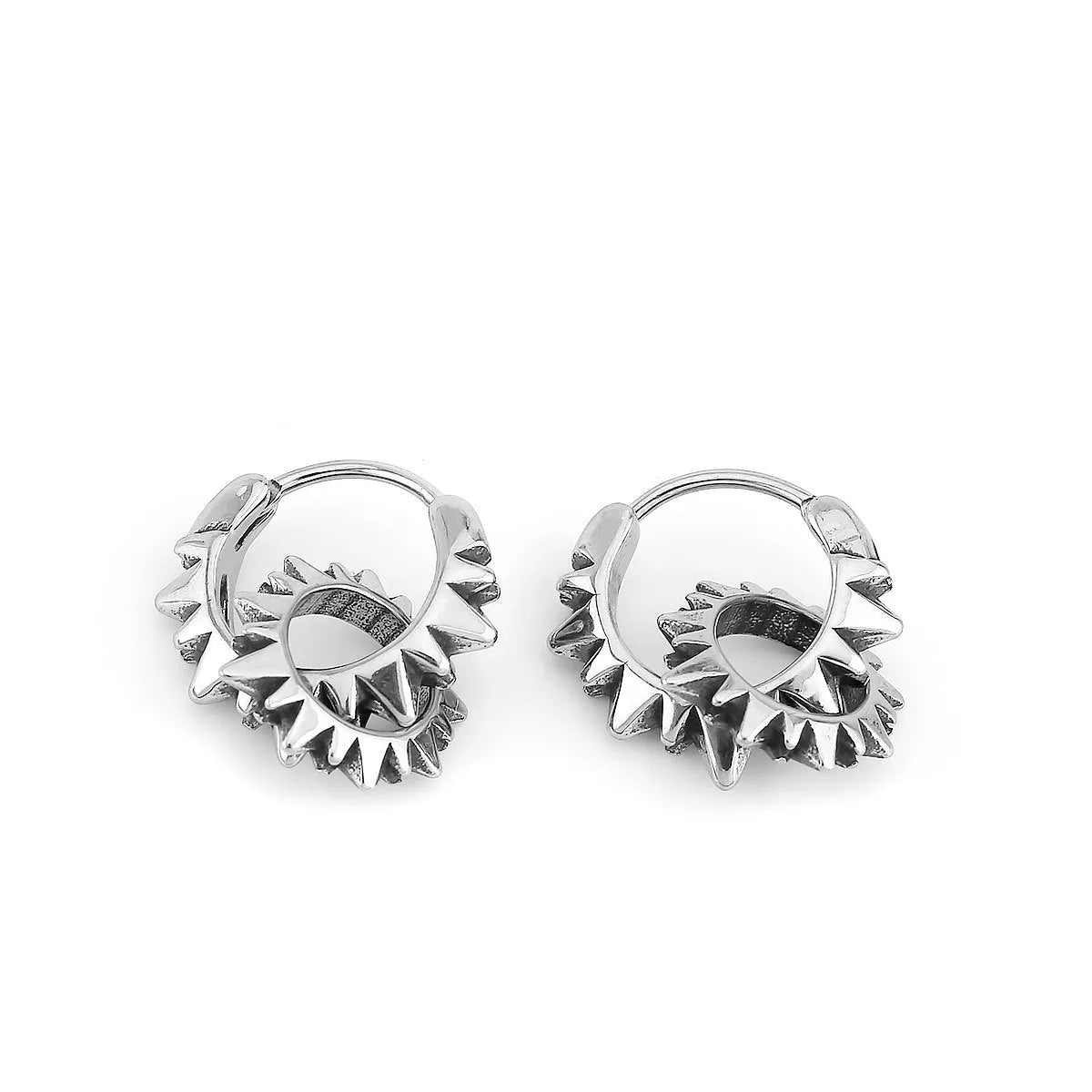A pair of polished steel-coloured stainless steel round ring earrings on a simple background.