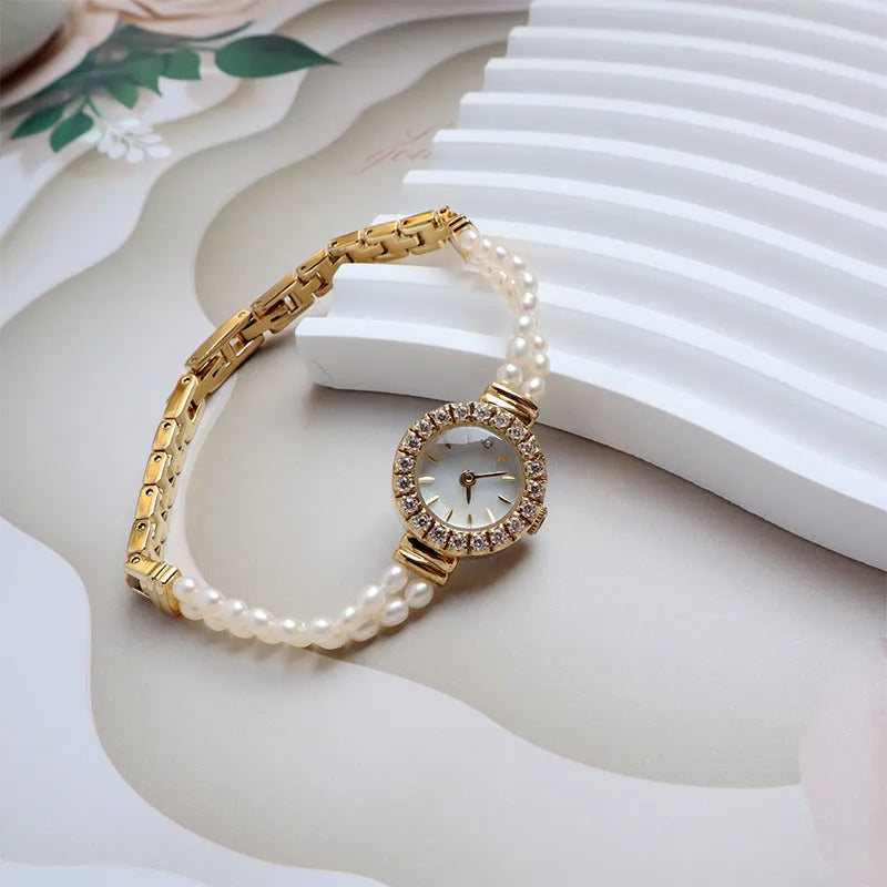 Women's light gold bracelet watch with freshwater pearls and an 18mm round dial.
