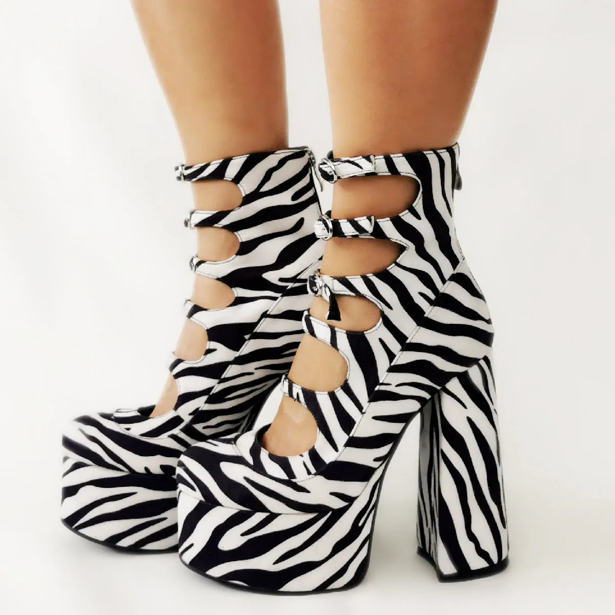 Women's black platform high heels with a thick heel, patent leather upper, and a serpentine design buckle.