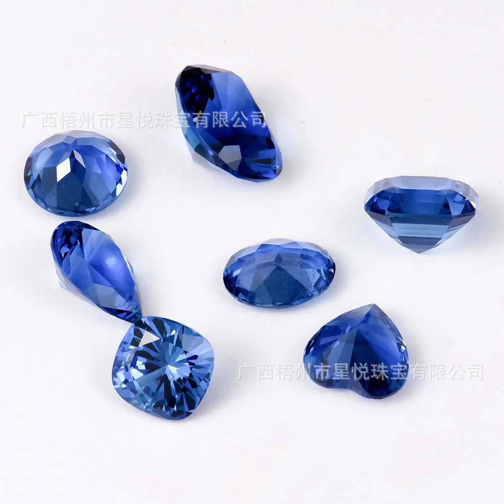 Royal blue cut gemstone in a heart shape on a plain background.