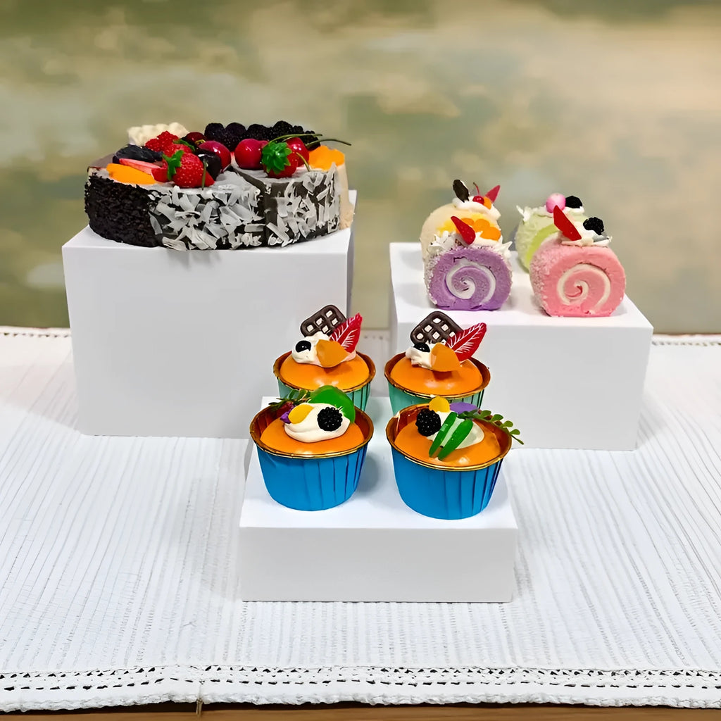 White plastic cube-shaped dessert display stands arranged on countertop for cake presentation