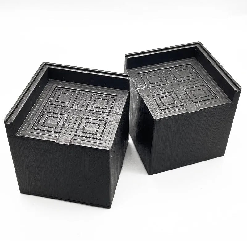Four black plastic bed foot mats for raising furniture height with modern simple style