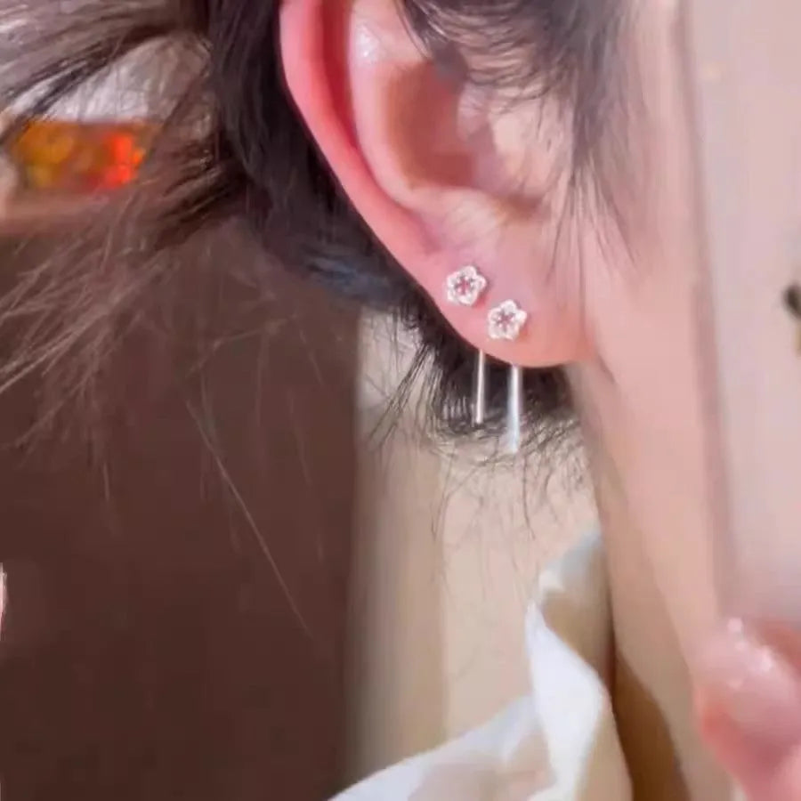 Silver hollow flower drop earrings with detailed petal design on hook closure